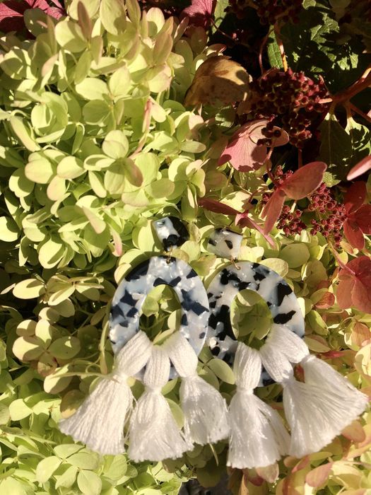Mytour editor's black-and-white marbled acrylic earrings adorned with white tassels.