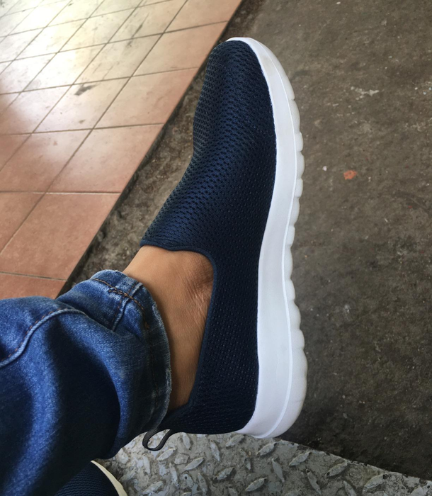 Reviewer wearing black walking shoes with white soles.