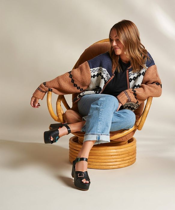 A model showcasing black sandals with colorful buckles for a playful touch.