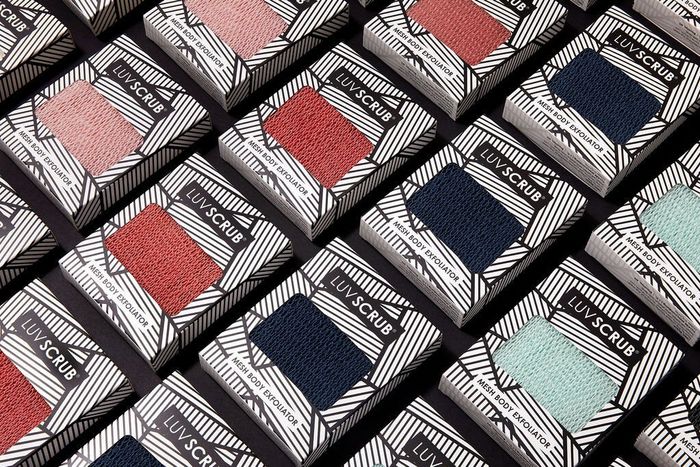 A variety of Luv Scrub exfoliators in shades of light pink, salmon, navy, and light blue.
