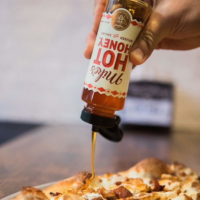 Honey being poured over a pizza