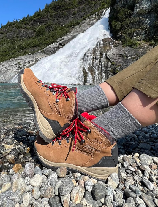 A reviewer wearing the tan hiking boots with striking red laces.