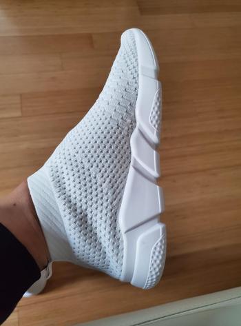 A reviewer wearing the white version of the sneakers.