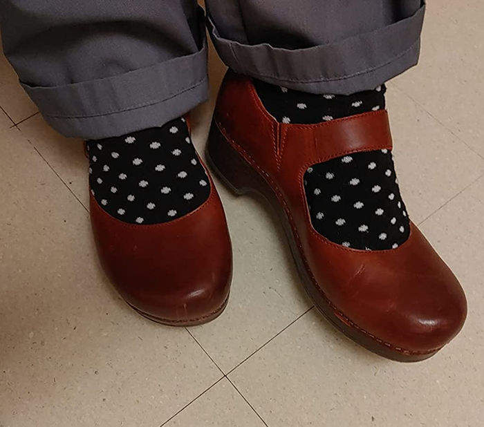 A customer wearing the burgundy clogs with fun polka dot socks.