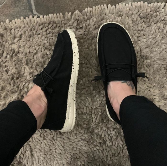 A reviewer showcasing the black shoes.