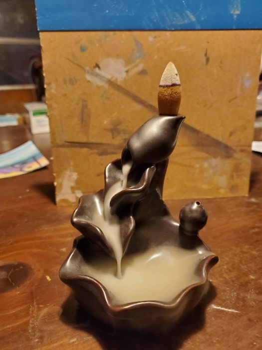 The milk-like smoke cascades down the holder like a serene waterfall.