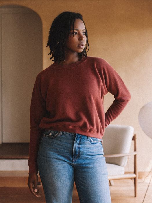A model showcasing a sumac-colored cropped sweatshirt