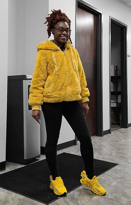 Image of a reviewer dressed in black leggings, a fluffy yellow jacket, and sneakers that perfectly match in yellow.