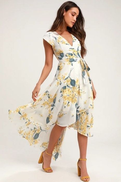 A photo of a model showcasing a floral high-low dress featuring cap sleeves