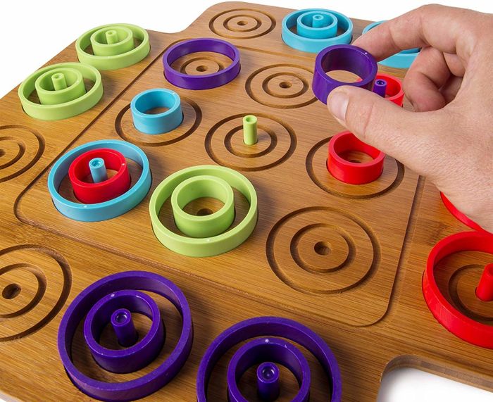 Concentric circle pieces arranged on Otrio's wooden game board.