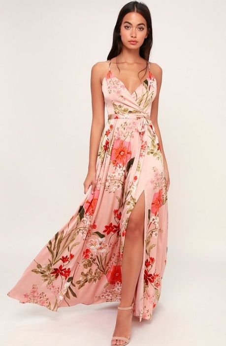 A model showcasing a floral satin maxi dress featuring adjustable spaghetti straps that elegantly crisscross at the back.