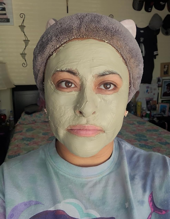 A reviewer is seen wearing the light green clay mask