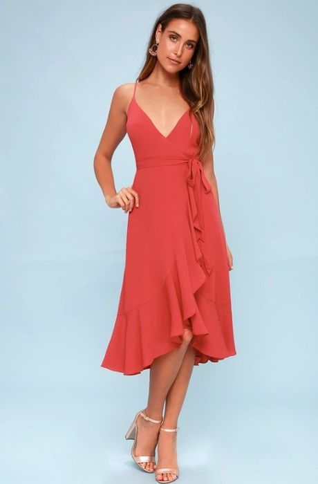 A model showcasing a berry pink wrap midi dress with adjustable straps and a chic high-low hemline.