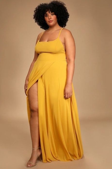 An image of a model wearing a stunning yellow backless maxi dress