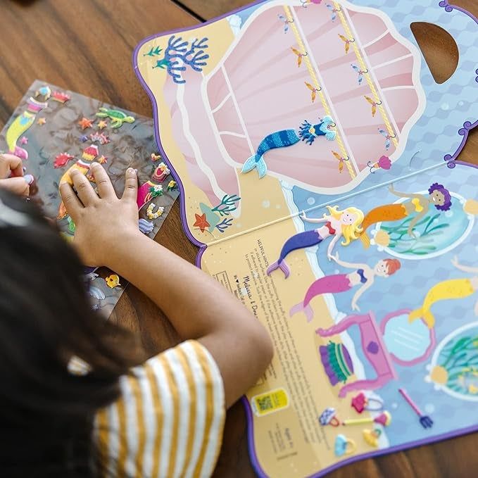 A child happily working on their sticker book.
