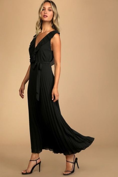 A model wearing a sleek black chiffon maxi dress with a V-neckline and an open back, perfect for formal occasions.