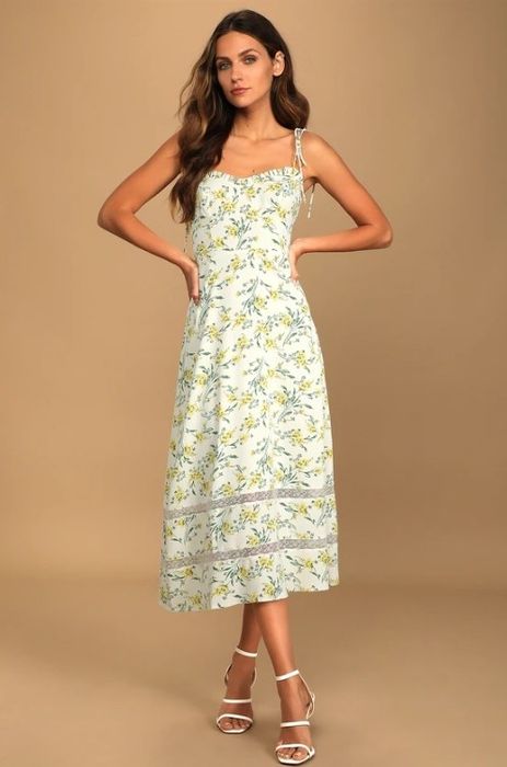 A model wearing a floral tie-strap midi dress with a ruffled sweetheart neckline, perfect for a variety of occasions.