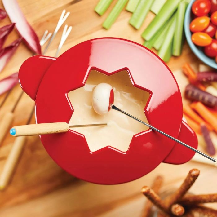 A bright red fondue pot filled with cheese