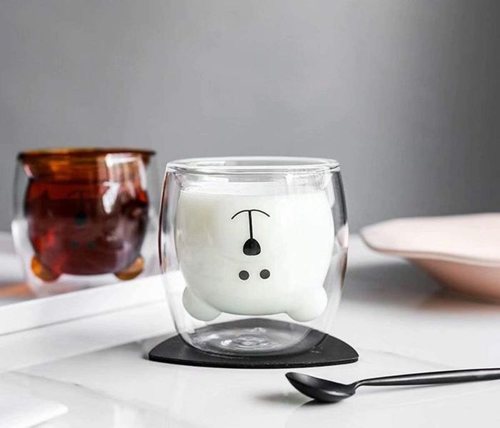 A clear cup with an inner layer shaped like an upside-down bear, complete with a painted black face.