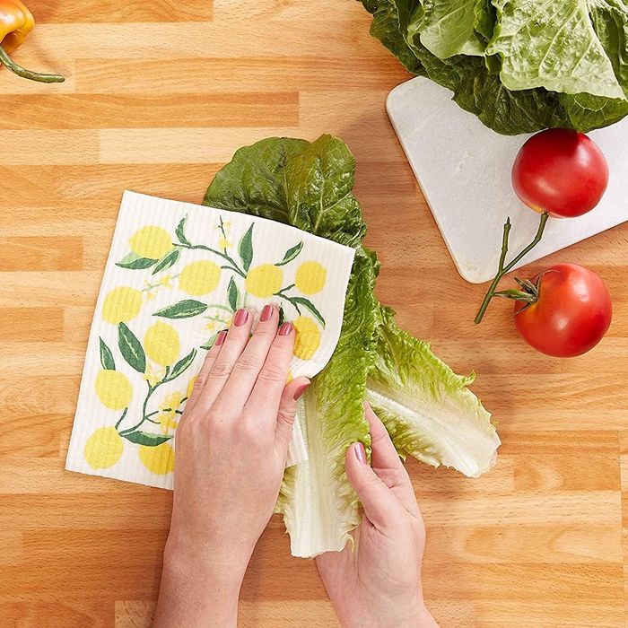 A person washing lettuce with a Swedish dishcloth.