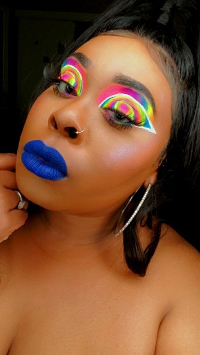 A reviewer applying the white liner paired with a colorful eye makeup look.