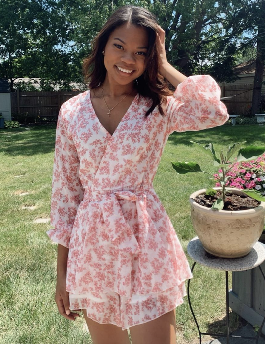 A reviewer sporting the white and pink floral romper.