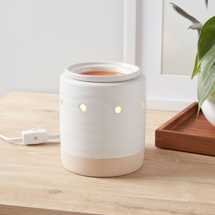 A wax melter in elegant white and tan.