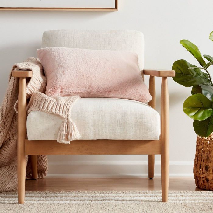 A soft pink pillow resting on a chair, adding a cozy touch.