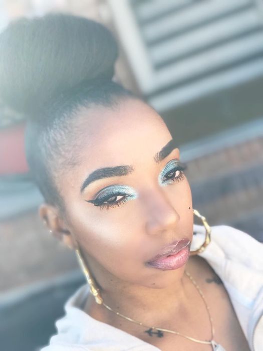 A reviewer showcasing a stunning blue glittery eye look.