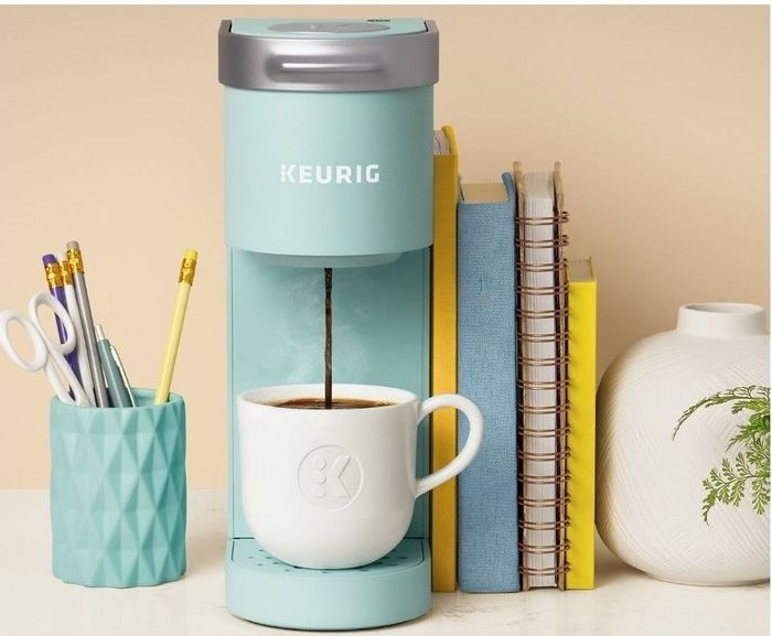 A compact blue single-serve coffee maker, perfect for brewing a quick and easy cup of coffee without taking up much counter space.