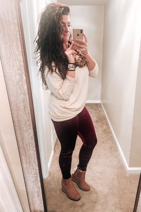 The reviewer is seen wearing the velvet leggings in a luxurious burgundy shade.