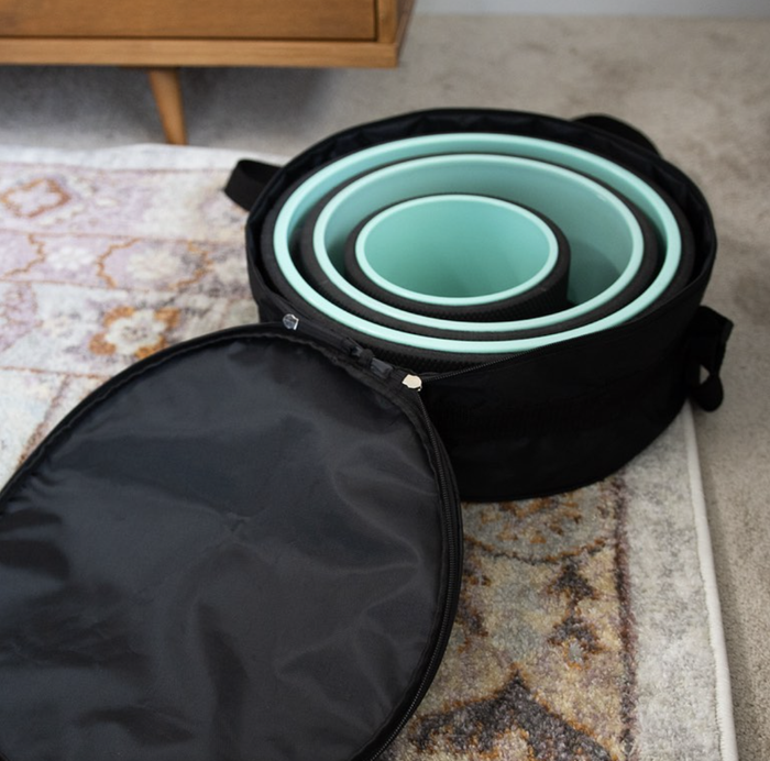 A set of three back massage wheels, each a different size, neatly stored in a zippered carrying case.