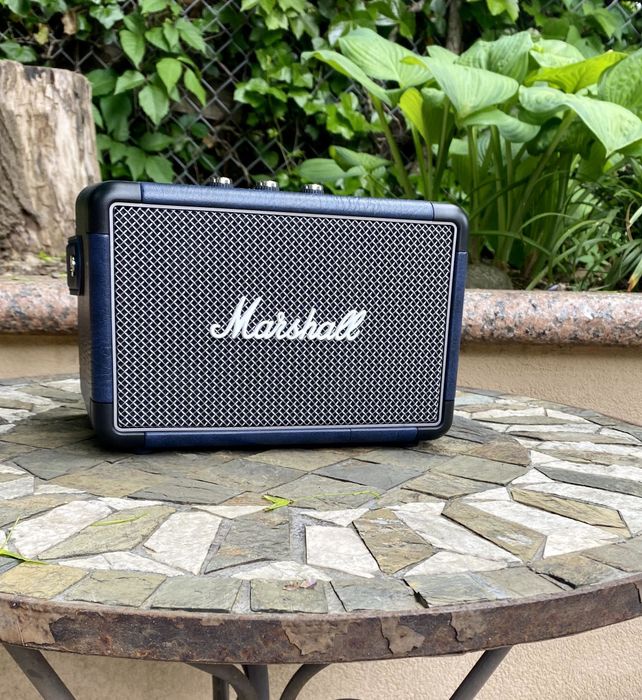 The black speaker placed on a table outdoors.