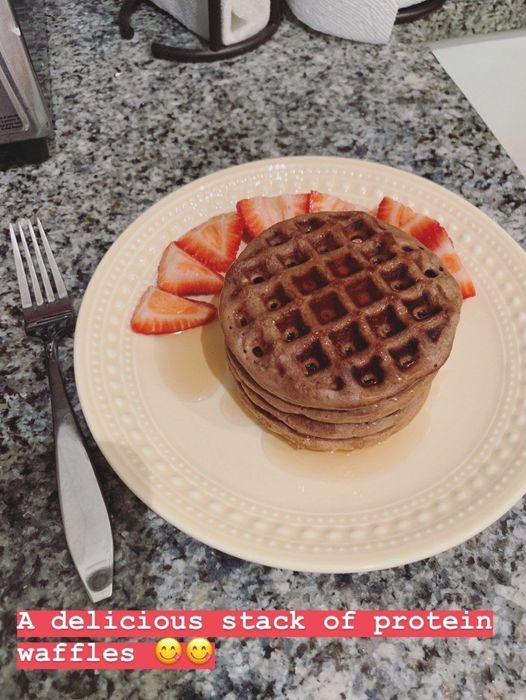 Waffles topped with fresh strawberries, labeled as 'a delicious stack of protein waffles'.