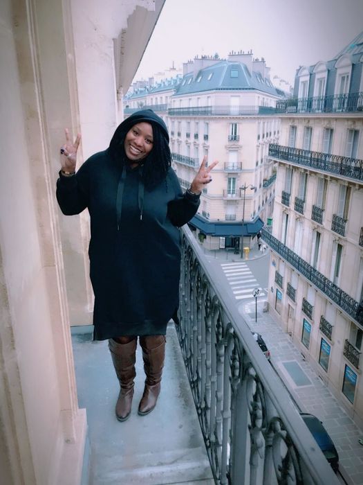 A reviewer showcases the knee-length hoodie dress in black.