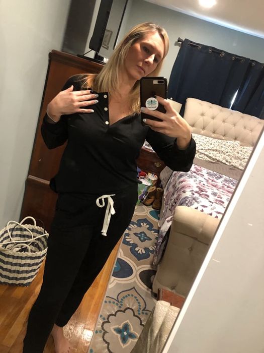A reviewer models the long-sleeved sweatsuit in classic black.