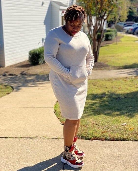 The reviewer is seen wearing the midi sweatshirt dress in a beautiful cream shade.