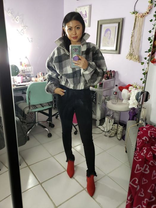 A reviewer showcasing the fleece in a classic black and white plaid pattern.