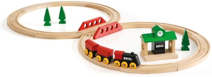 A traditional wooden train set complete with tracks, a train, a station, and trees.