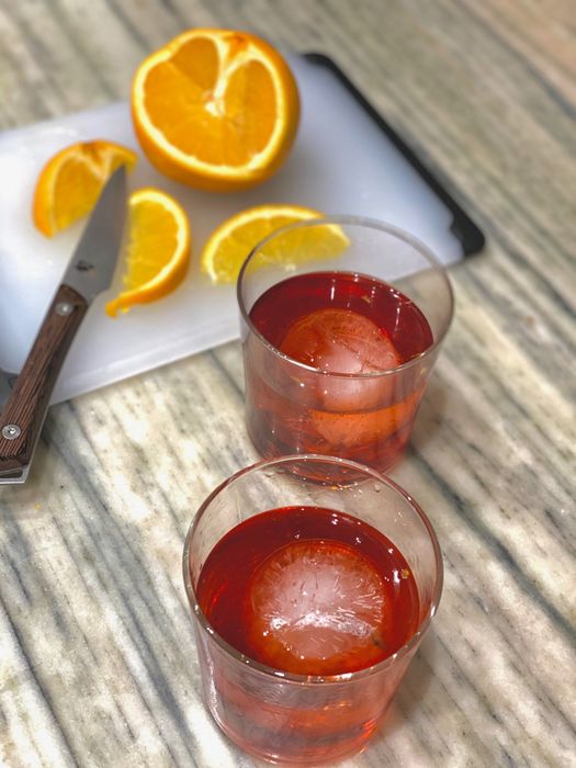 Two beverages featuring the large ice cubes inside them.