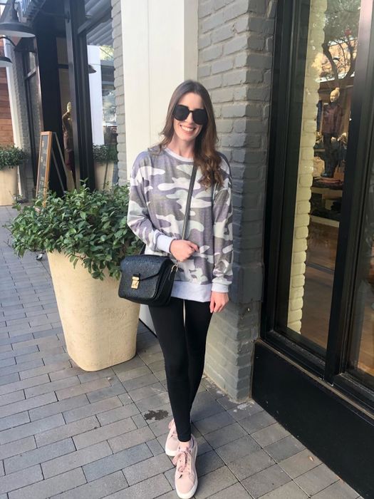 A reviewer wearing the sweatshirt in a stylish grey camouflage print.