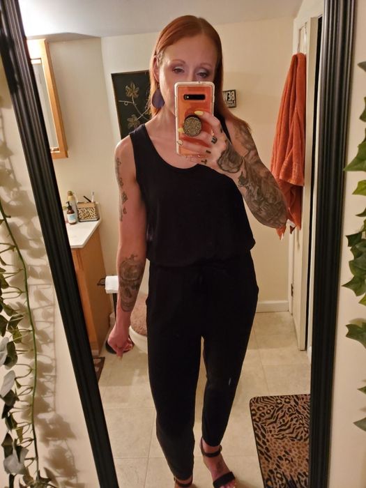 The reviewer is sporting the jumpsuit in a sleek black shade.