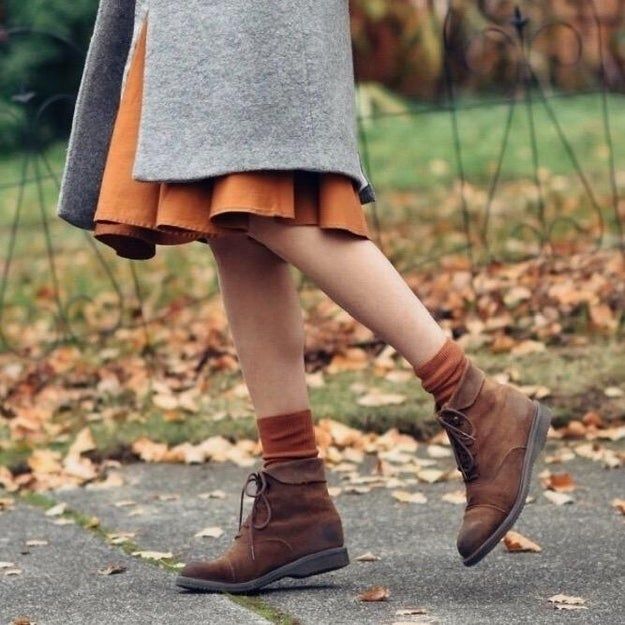 A photo of a reviewer showing off orange socks worn under their tan boots.