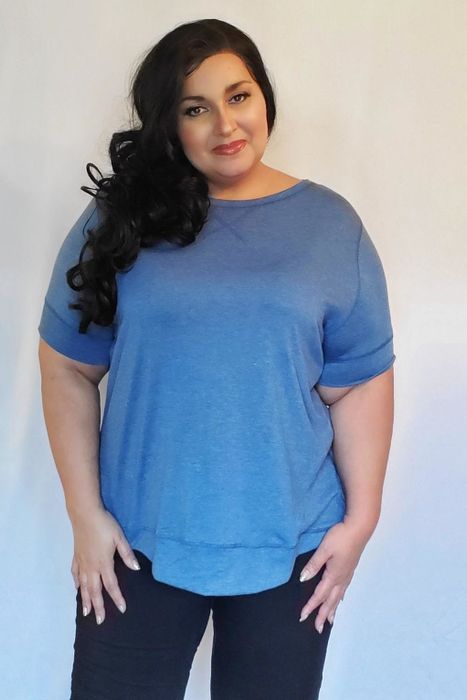 A reviewer shows off the blue short-sleeve tunic.