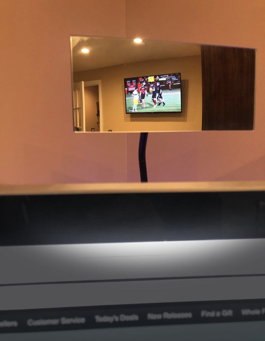 A closeup of another mirror reflecting a football game