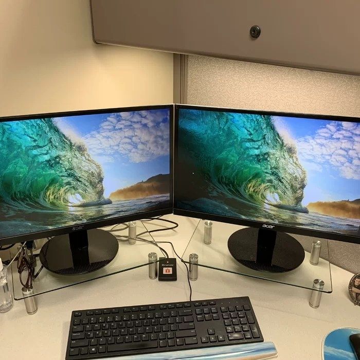A reviewer’s photo of the monitor stands holding two monitors in place.