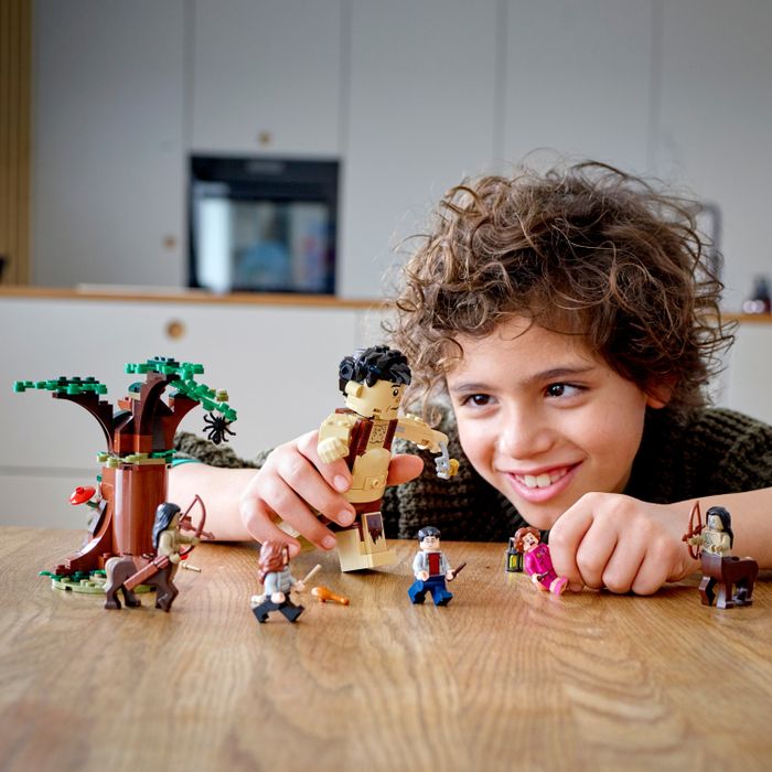 A child playing with a Harry Potter-themed Lego set, recreating the iconic scene from the Forbidden Forest.