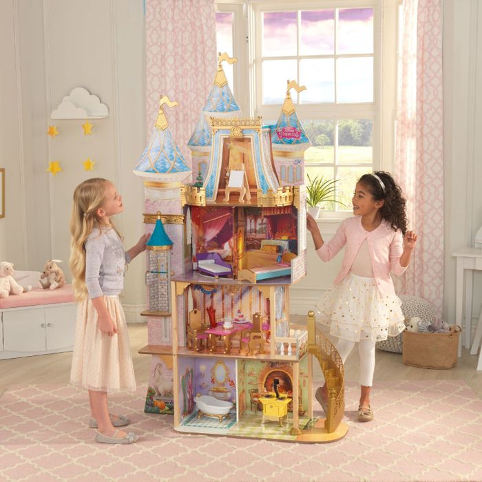 two children playing with a wooden Disney Princess play castle