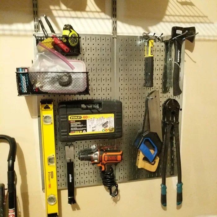 A reviewer’s photo displaying the Galvanized Steel pegboards, effectively organizing an assortment of tools.