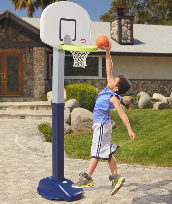 A child making an impressive slam dunk into the Little Tikes basketball hoop.